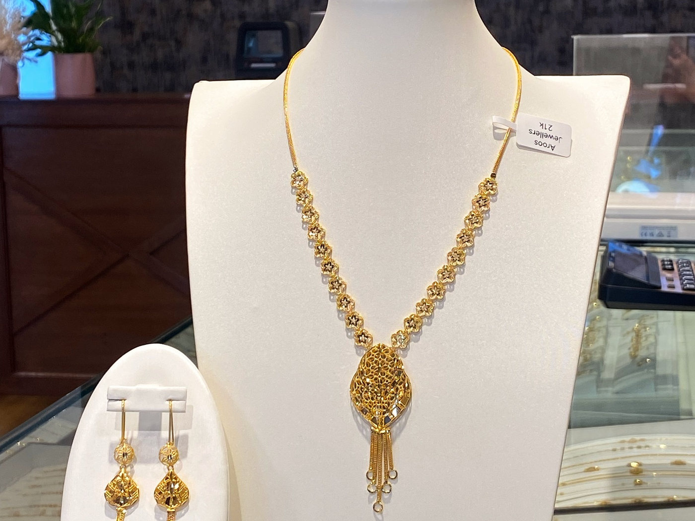 A wide 22 carat gold collar necklace worn at the collarbone